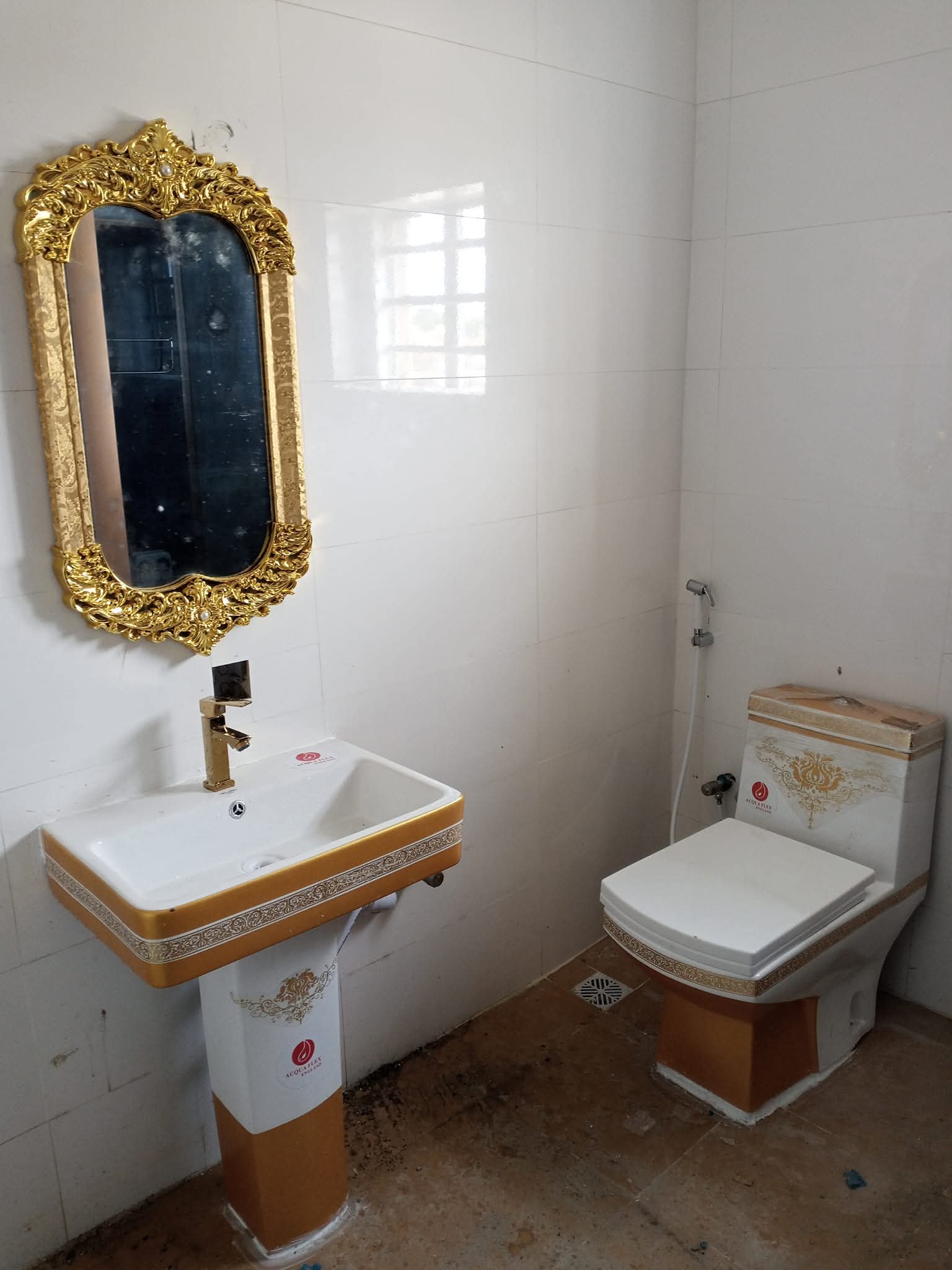 Gold-trim pedestal basin, ornate mirror and matching one-piece WC with bidet spray
